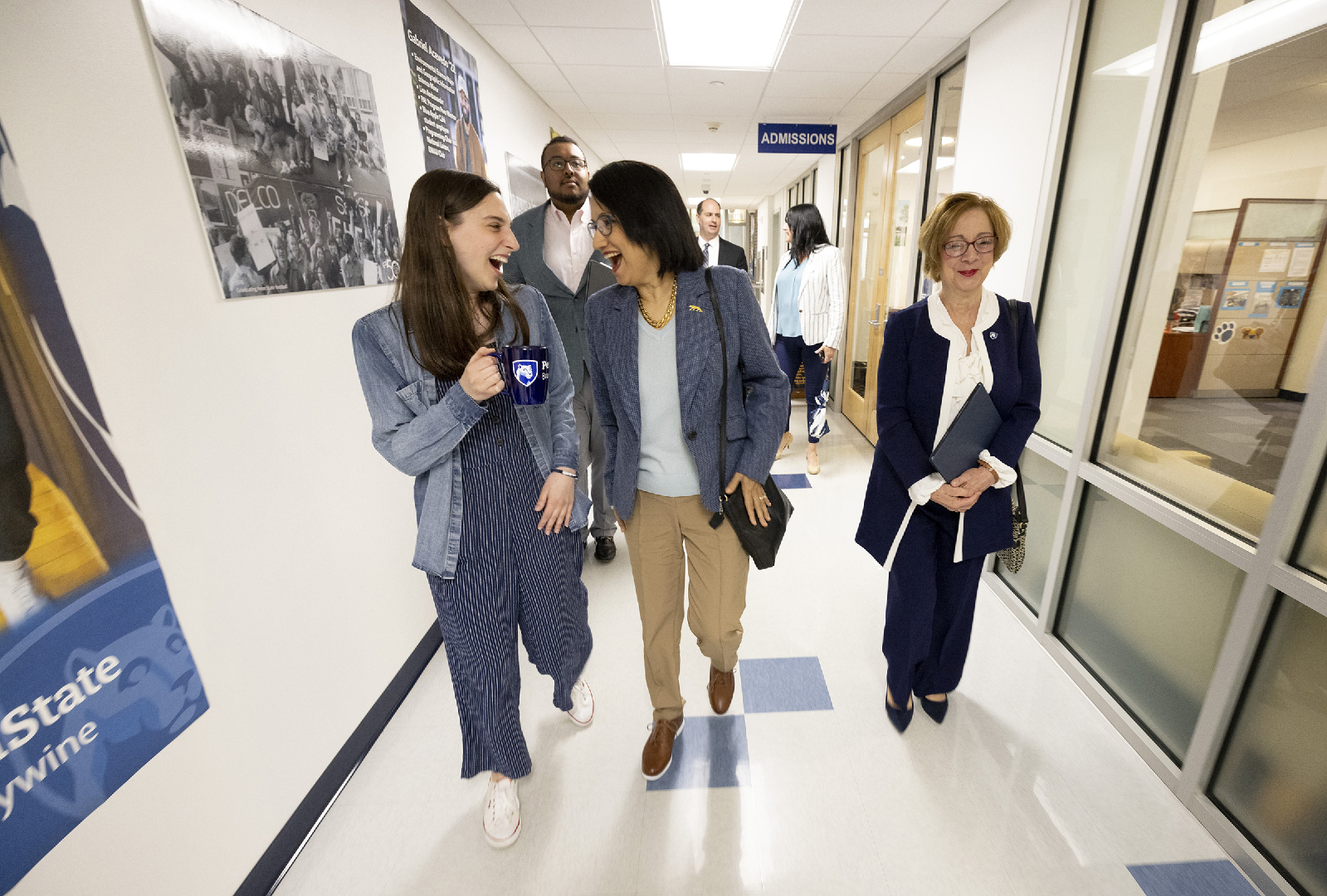 Three women walk down a hallway.