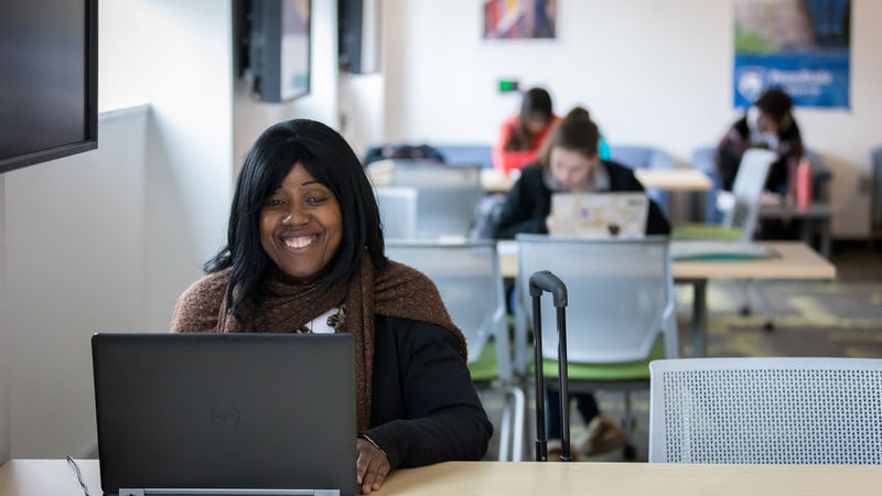 Karla Pew sitting at a table with her computer