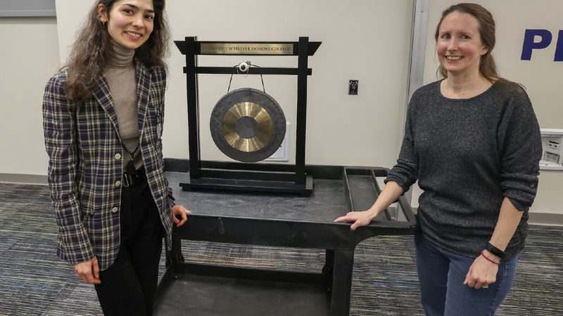 Anna and Nora standing with a gong