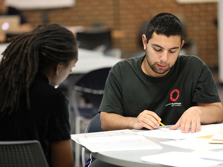 Male tutor teaching female student