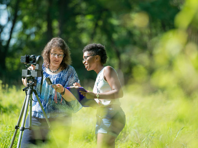 Professor working with a female student outdoors