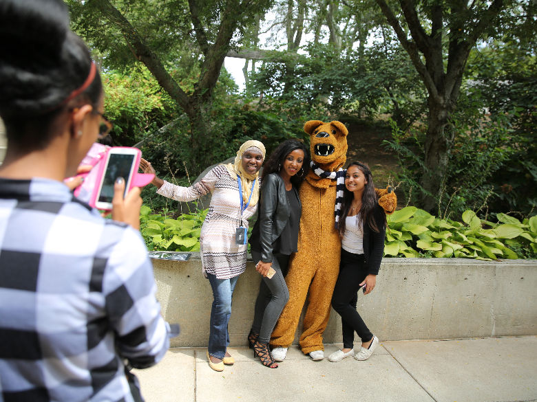 Students taking photo of friends with mascot
