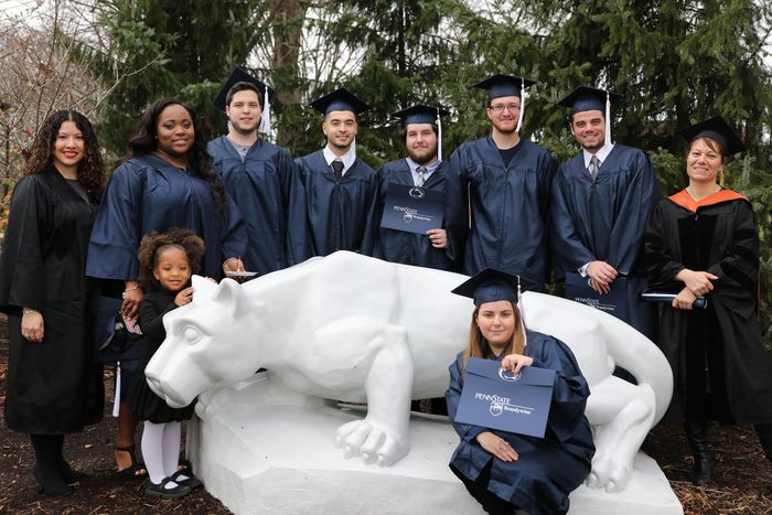 Students and faculty stand at the lion shrine
