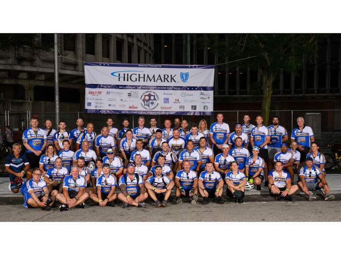 Delco 476ers team posing for photo in front of sign displaying sponsors