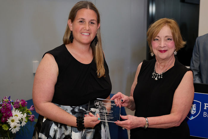 A woman receives an award from another woman.