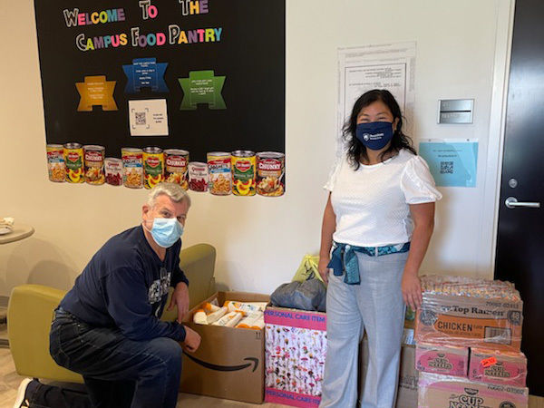 man and woman in masks with donated food