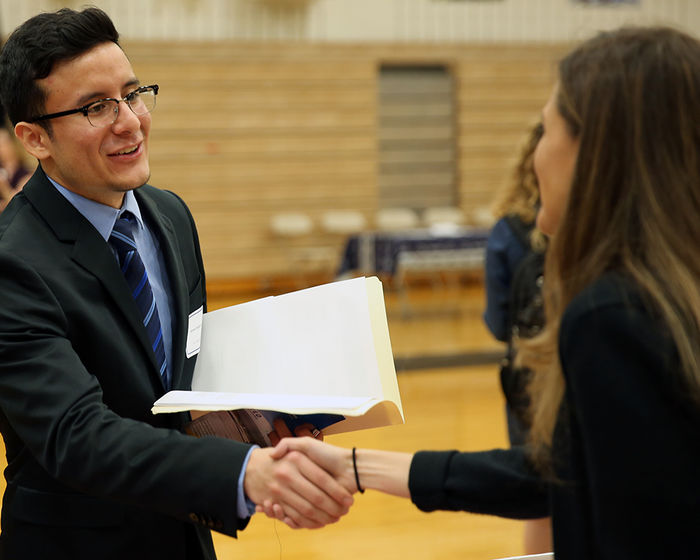 student shaking hands with a potential employer