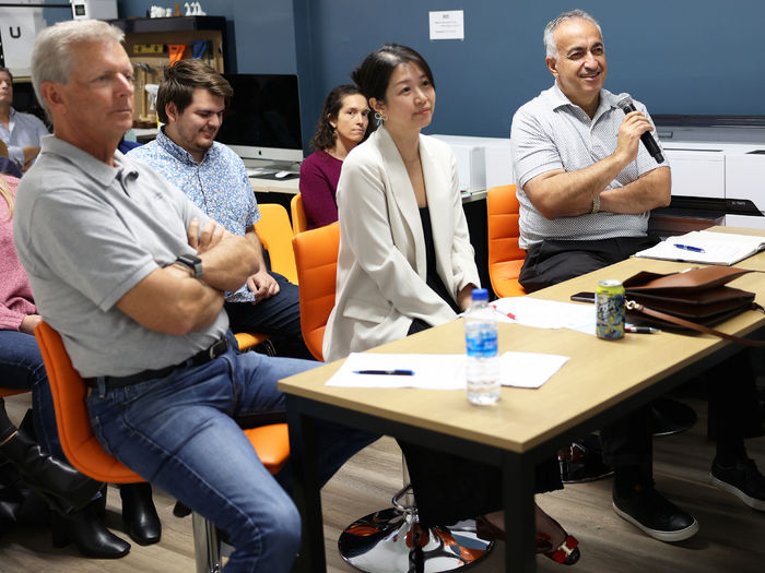 Three judges sit at a table with one holding a microphone.