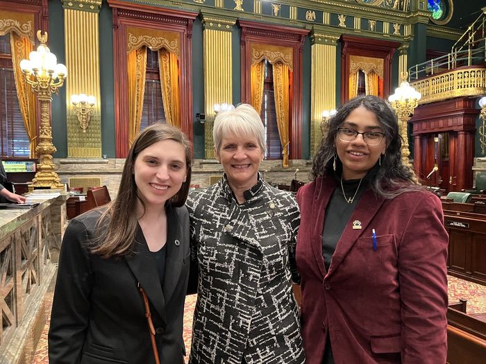 Three women stand in the Pennsylvania Senate Chamber.