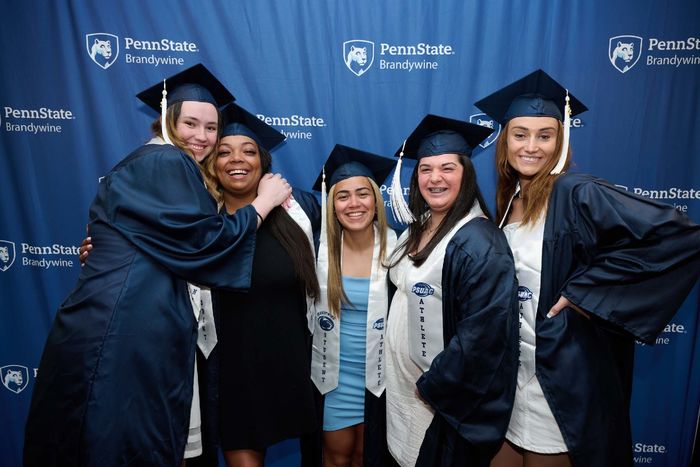 Five women stand in front of a banner.