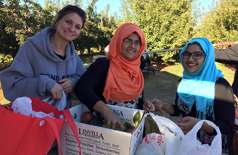 3 female students with apples