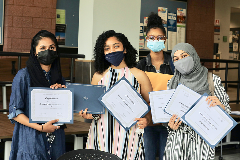 A group of female students sharing their award certificates.