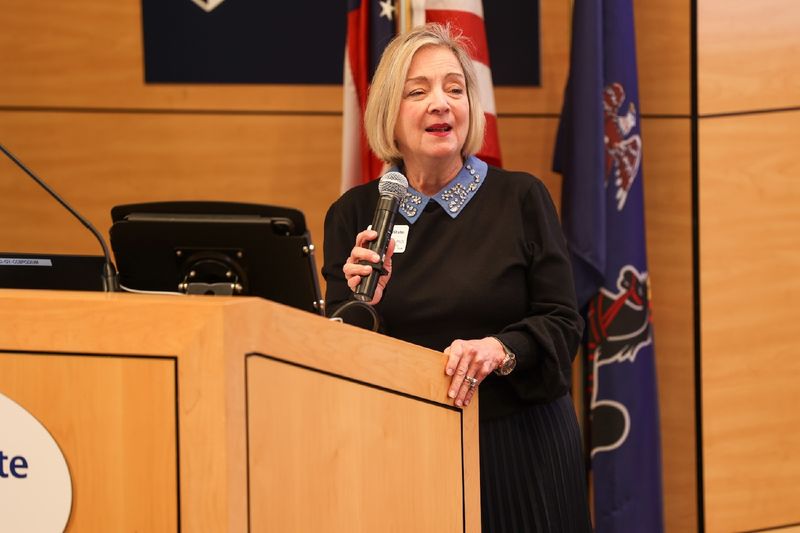 Regional Chancellor Marilyn J. Wells holding microphone