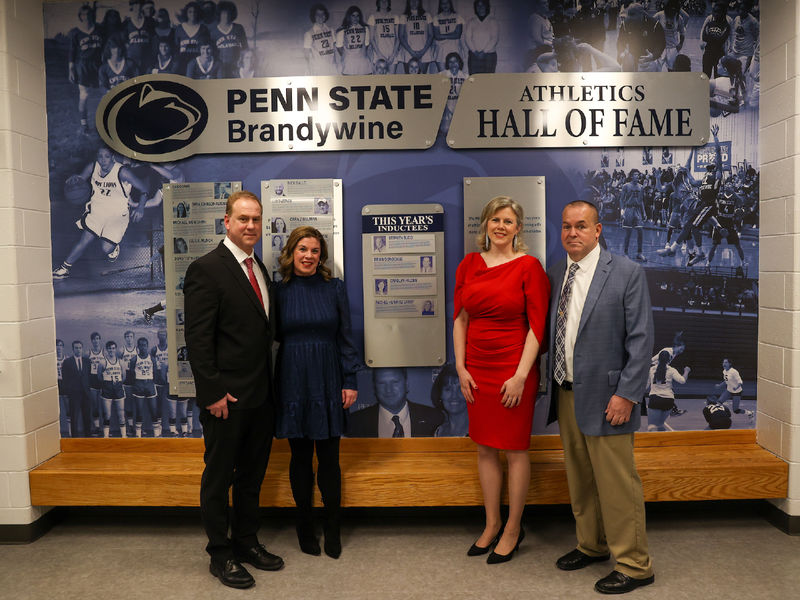 hall of fame inductees standing in front of hall of fame wall