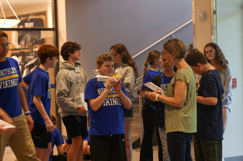 students flying paper airplanes