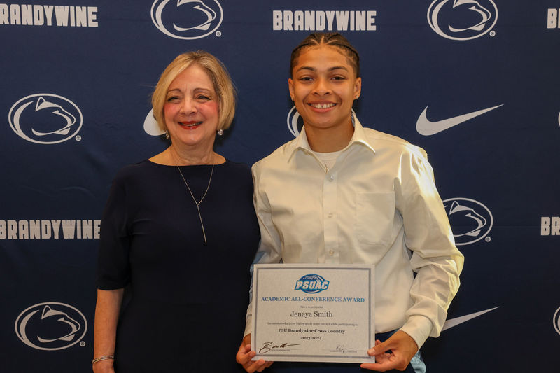 student holding award with Chancellor Wells