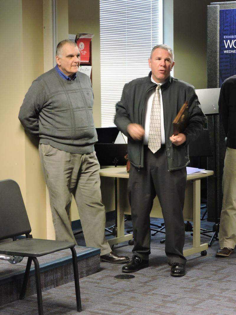 Officer Bill receives a plaque from a colleague