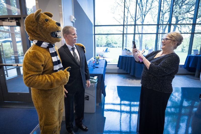 someone taking a photo of a person with the Nittany Lion