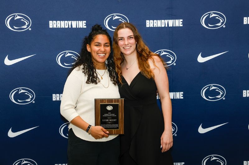 student and staff holding plaque