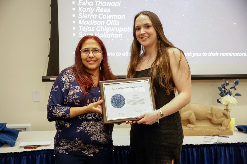 student and staff member with award