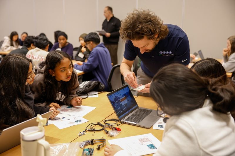 man helping students with workshop