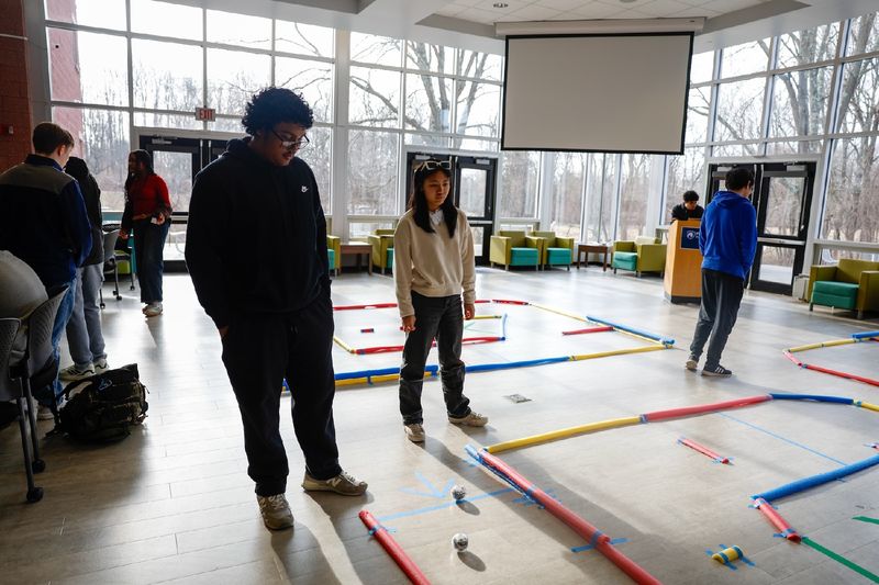 Students standing with robots