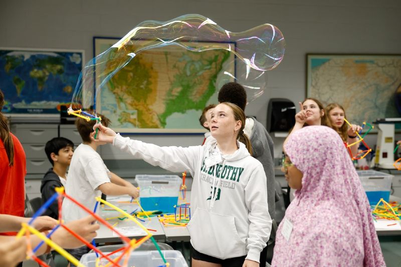 student waving bubble wand
