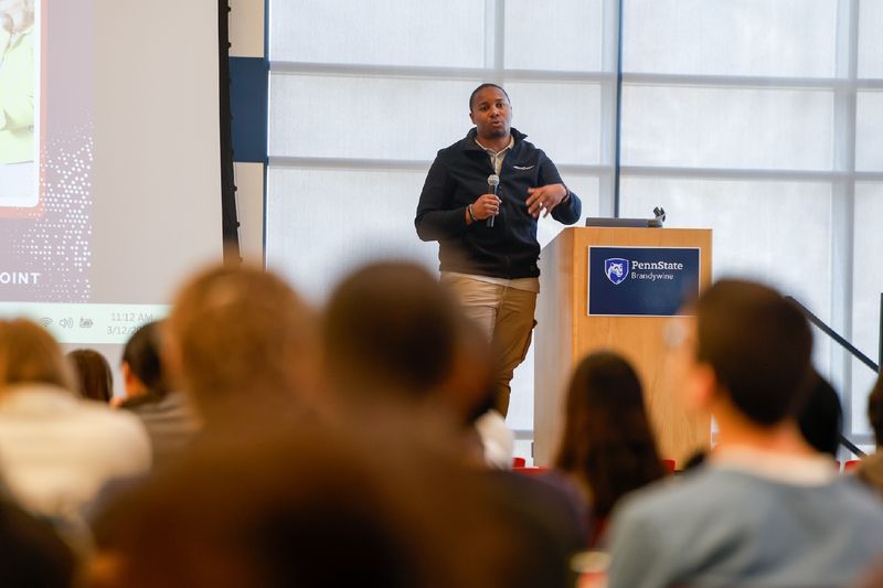 man talking in front of a crowd