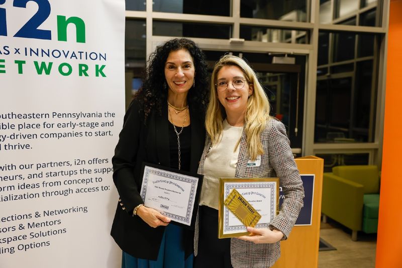 two ladies holding certificates