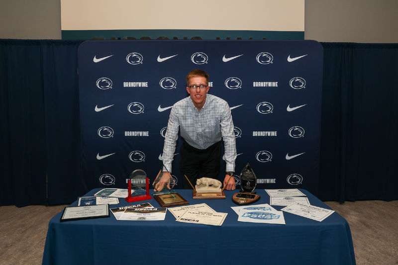 man at a table with awards