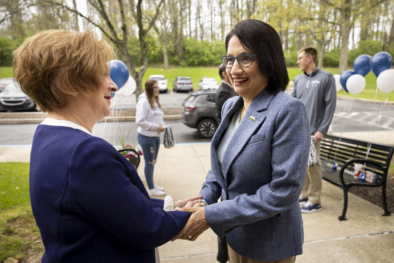 Two women shake hands.