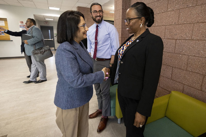 Two women shake hands.