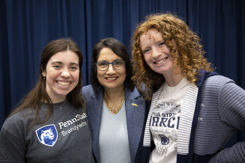 Three women stand together.