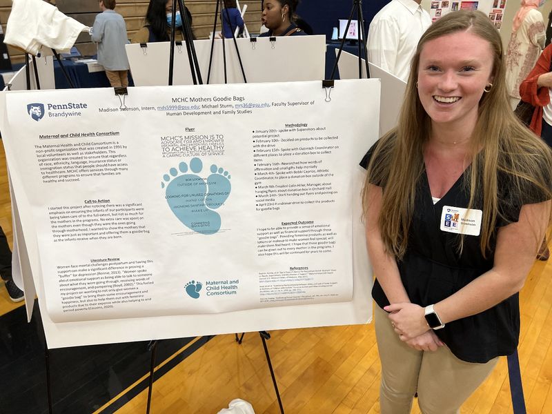 A women stands next to her poster about her internship.