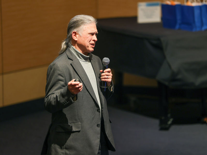 man on stage talking into a microphone