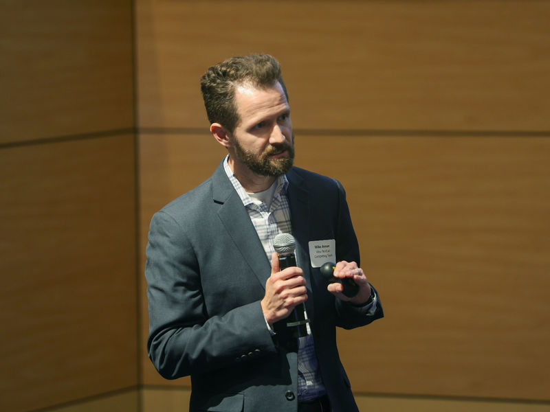 man speaking on stage with microphone