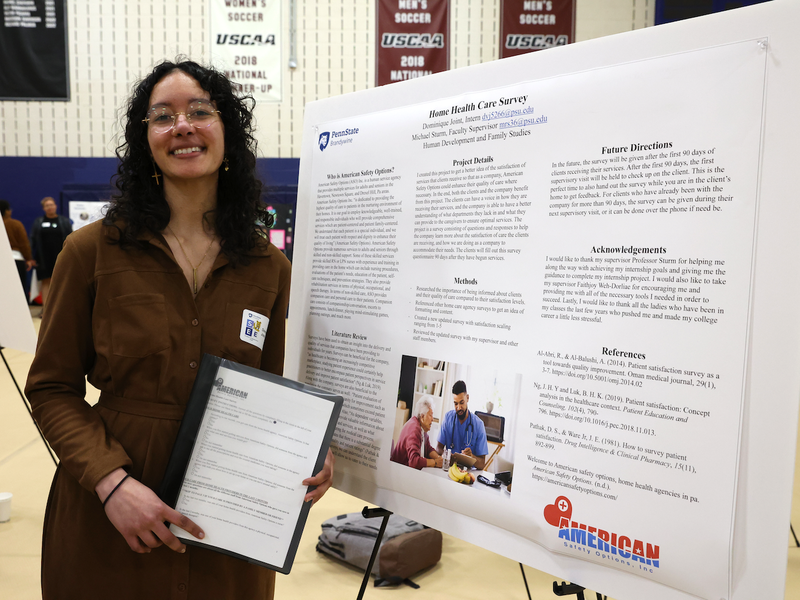 Student standing in front of a poster board