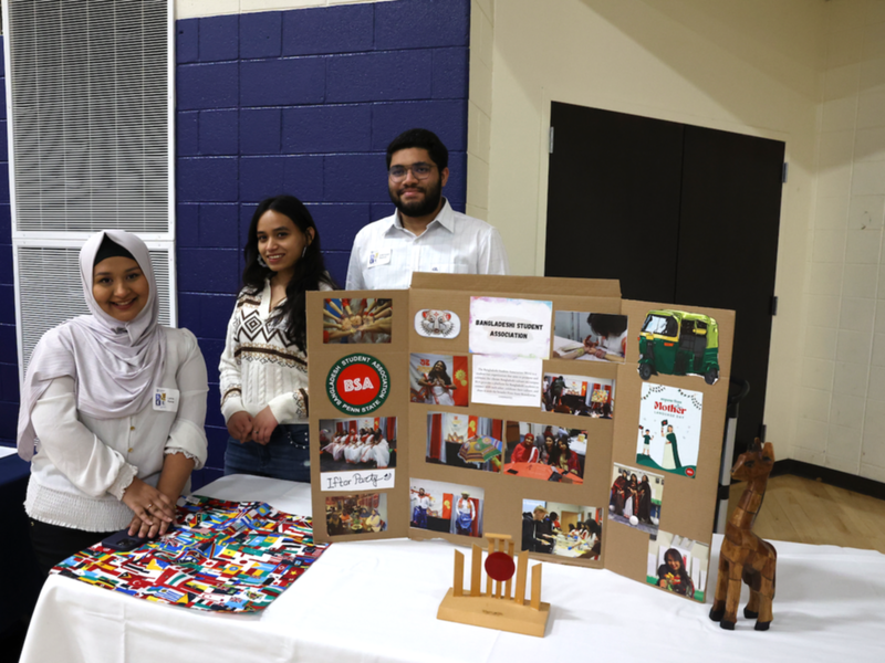 Students standing behind Bangladeshi Student Association poster