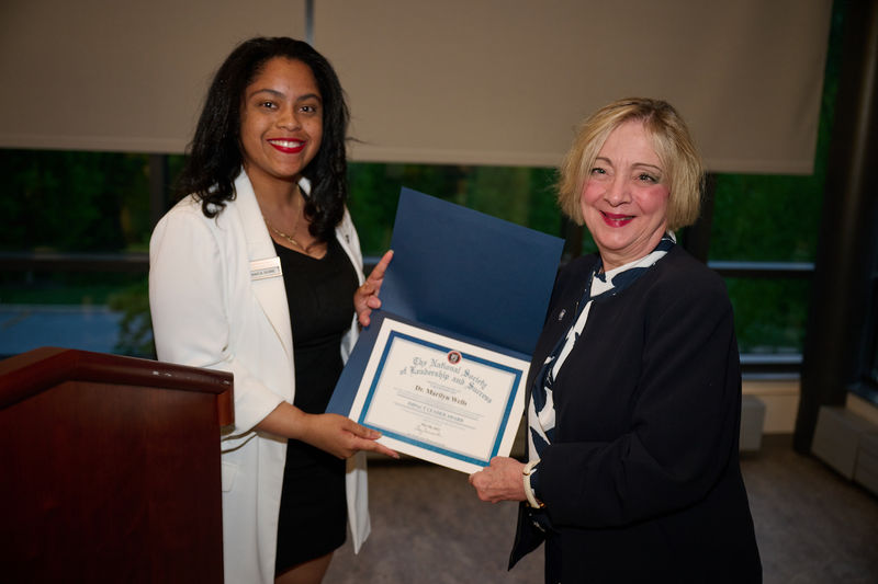 woman holding certificate and standing next to woman