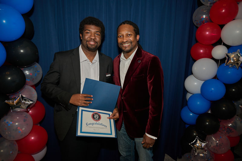 two men standing holding a certificate