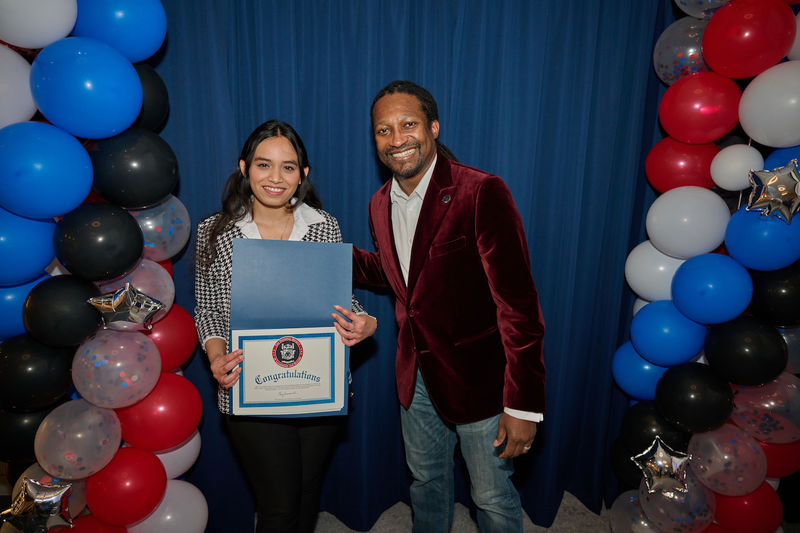 woman holding certificate and standing next to man