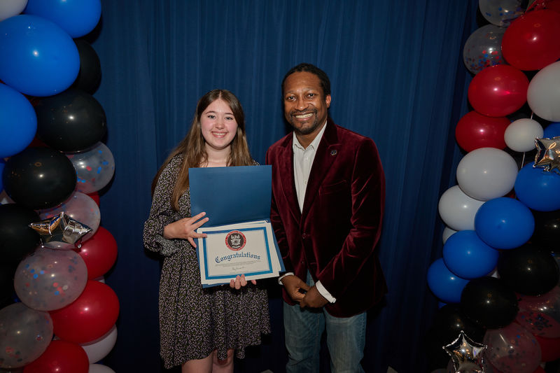 woman holding certificate and standing next to man