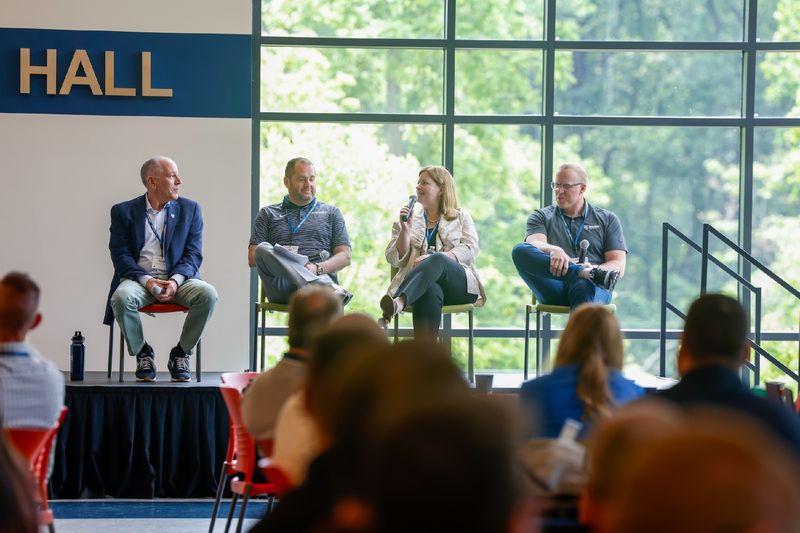 people sitting on a panel on stage