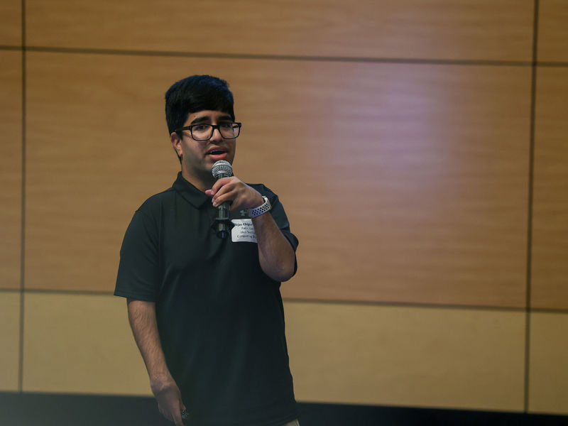 man speaking into microphone on stage