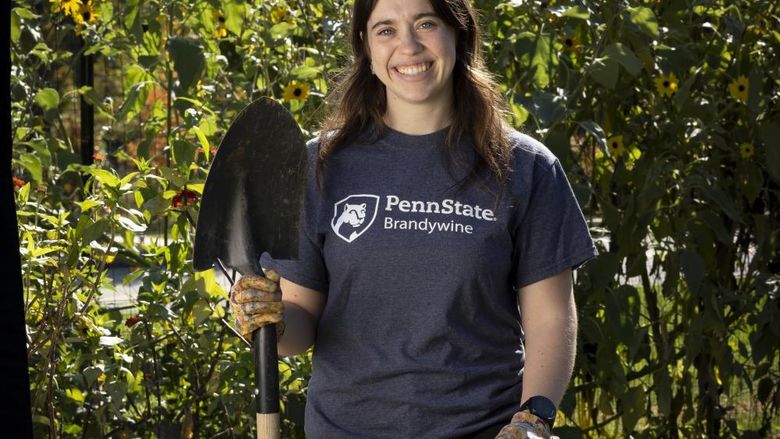 McKenna holding a shovel in a garden