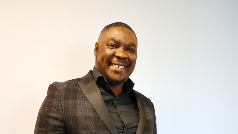 Olugbenga's smiling for his headshot 