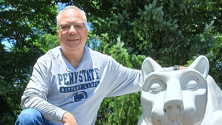 George Eleftherakis posing next to the Penn State Nittany Lion shrine
