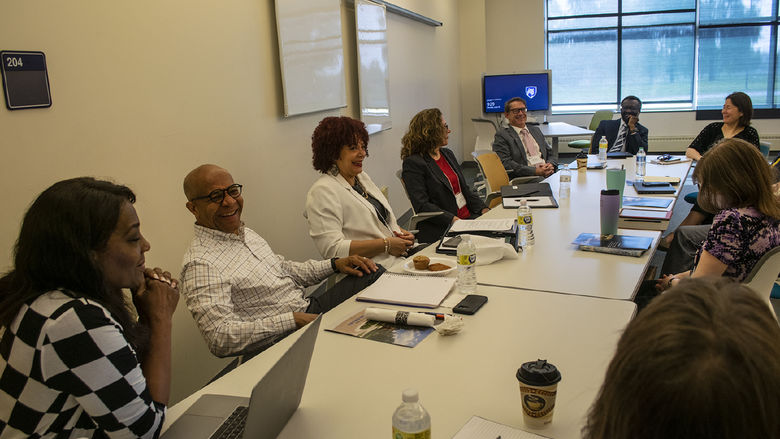 A team from Penn State Harrisburg talks while sitting around a large conference table