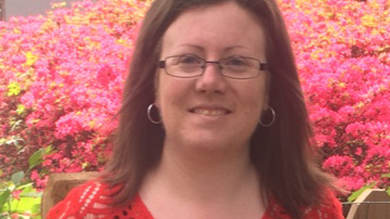 Lauren Jerla smiling in front of flowers