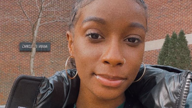 Zhane smiling in front of the Main Building at Brandywine